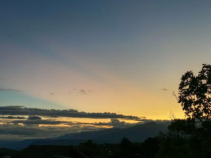 Cielo del atardecer sobre las montañas que rodean a Barichara, con la silueta de un árbol a la derecha