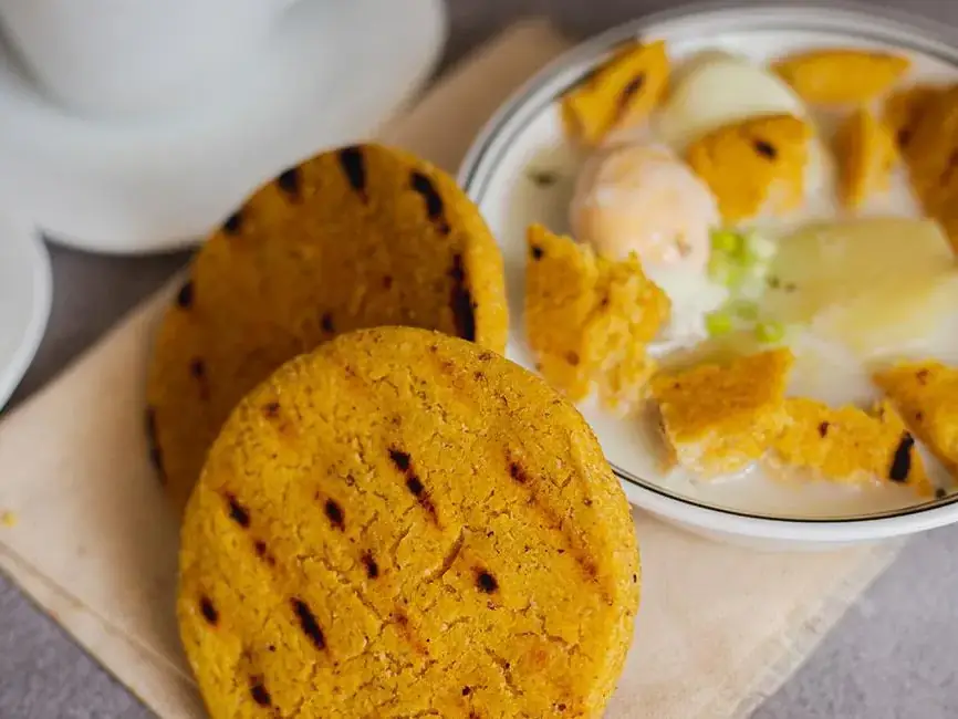 Arepas santandereanas de maíz recién asadas, servidas con queso y huevo