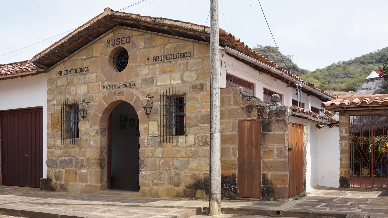Fachada de piedra del museo paleontológico y arqueológico de Guane, con su nombre tallado sobre una puerta en arco y una ventana redonda