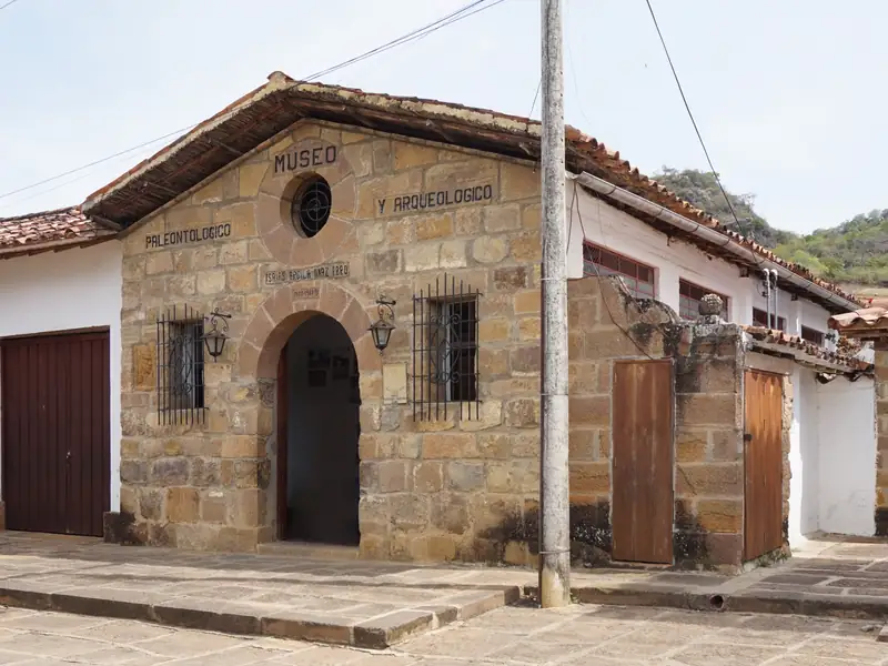 Fachada de piedra del museo paleontológico y arqueológico de Guane, con su nombre tallado sobre una puerta en arco y una ventana redonda